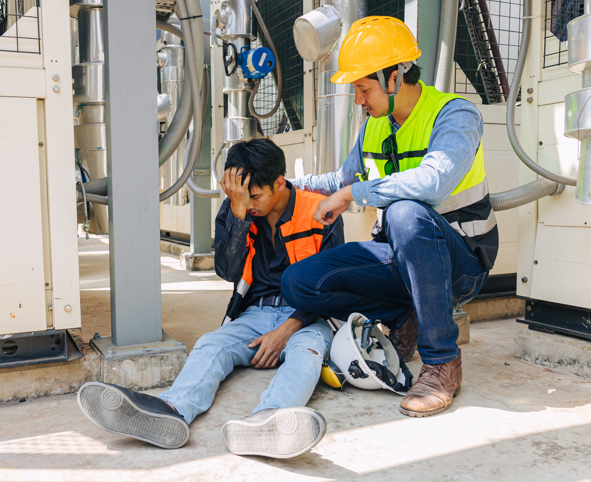 Man kneeling down to help other man who fainted